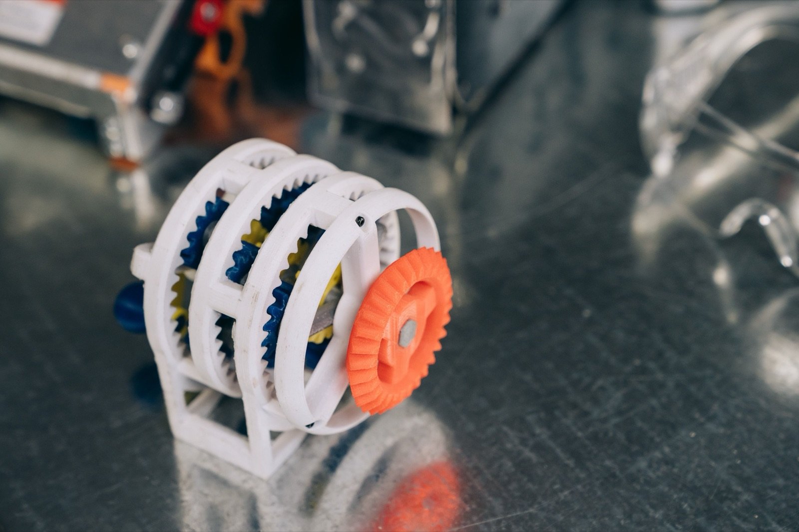 Mecanismo de engranajes impreso en 3D con varios colores, mostrando piezas funcionales de precisión